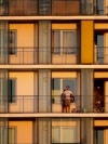 ROMANIA -- A Romanian man watches the sunset from the balcony of his flat in Bucharest, April 6, 2020